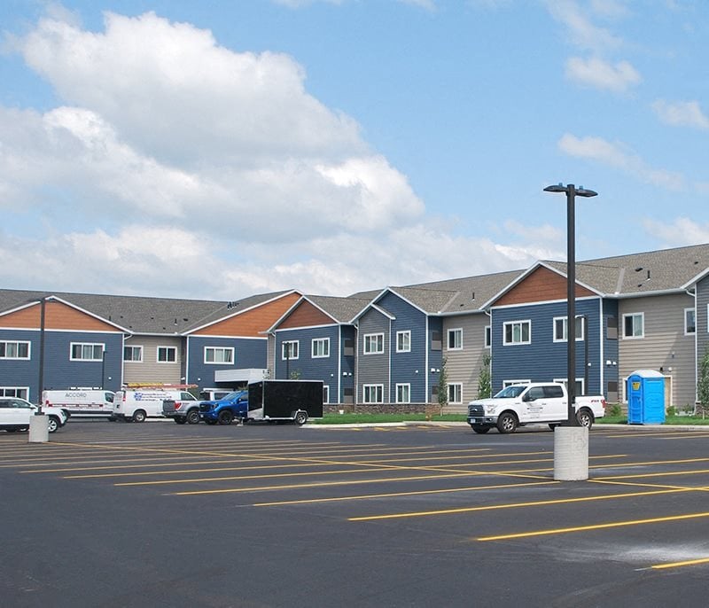 a row of apartment buildings in a parking lot